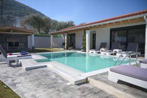 a swimming pool with chairs and a house at Diamond Luxury Villa Corfu 5 Bedroom Luxury Villa in Mesongi