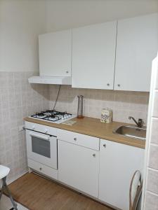 a white kitchen with a stove and a sink at Il Borgo in Corbara