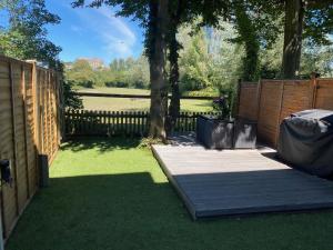 a backyard with a wooden fence and a tree at Stylish Townhouse with views of Arundel Cathedral in Arundel