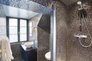 a bathroom with a shower with a toilet and a sink at Hôtel Aero Paris Passy in Paris