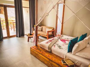 a bedroom with a bed and a chair in a room at Zanzibella Hotel & SPA in Kiwengwa