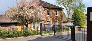 een zwart hek voor een huis met een boom bij #8 Brunel House Luxury Apartment in Great Malvern in Great Malvern