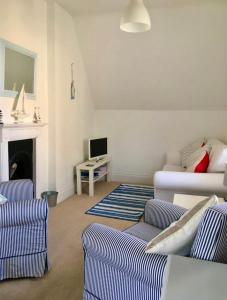 a living room with a couch and a tv at Quirky Lyme Regis Apartment Near Beach in Lyme Regis