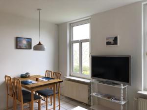 uma sala de estar com uma mesa de jantar e uma televisão em Apartments Schnepel em Sankt Michaelisdonn