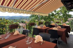 um restaurante com mesas e cadeiras castanhas com vista em Hotel Locanda Al Pomo d'Oro em Cividale del Friuli
