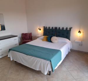 ein Schlafzimmer mit einem großen Bett und einem Stuhl in der Unterkunft Casa di Jacu in Favignana