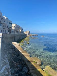 skaliste wybrzeże z budynkami i oceanem w obiekcie Casa vacanza da Paola w Trapani