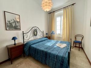 une chambre avec un lit recouvert d'une couette bleue dans l'établissement Levanto Rentals, à Levanto