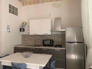 a kitchen with a refrigerator and a table with chairs at Bruco Holiday in Polignano a Mare