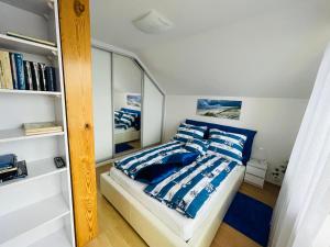 a bedroom with a bed with blue and white pillows at Apartament Bystrzycka in Gdańsk