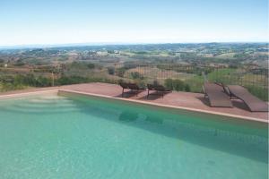 a swimming pool with chairs and a view of the countryside at Crealto in Alfiano Natta