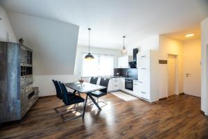 ガムリッツにあるFerienwohnung Weingut Birnstinglのテーブルと椅子のあるキッチンとダイニングルーム