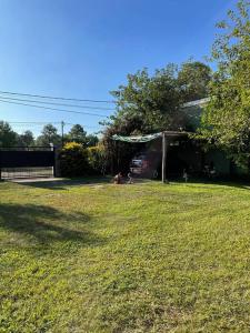 a yard with a family sitting in the grass at Casa-quinta Colastine Norte, Santa fe Argentina in Santa Fe