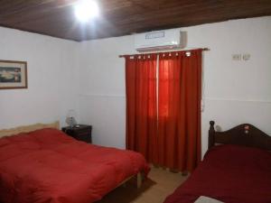 a bedroom with a bed and a red curtain at Casa-quinta Colastine Norte, Santa fe Argentina in Santa Fe