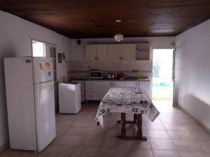 a kitchen with a table and a white refrigerator at Casa-quinta Colastine Norte, Santa fe Argentina in Santa Fe