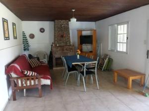 ein Wohnzimmer mit einem Tisch, Stühlen und einem Sofa in der Unterkunft Casa-quinta Colastine Norte, Santa fe Argentina in Santa Fe
