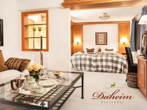 un soggiorno con tavolo e letto di Gästehaus Daheim a Riezlern