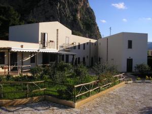 a white building with a mountain in the background at Baglio Makari in San Vito lo Capo