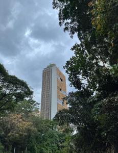 un edificio alto con árboles delante de él en Ceylonz Suite en Kuala Lumpur