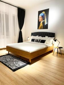 um quarto com uma cama e um quadro de uma mulher em Old Town Superior Apartment by MRG em Bucareste