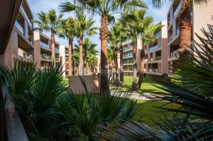 uitzicht op de binnenplaats van een gebouw met palmbomen bij Coco Design Apartment Salgados Beach - By Dalma Portuguesa in Galé
