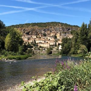 een stad op een heuvel naast een rivier bij Les Roches in Comprégnac