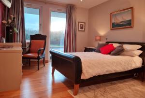 ein Schlafzimmer mit einem Bett, einem Stuhl und einem Fenster in der Unterkunft Hazelwood Country House in Adare