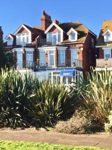 uma casa grande com arbustos à frente em Seaview Sanctuary em Eastbourne