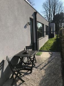 une table de pique-nique et un banc à côté d'un bâtiment dans l'établissement Au Calme, à Sint-Genesius-Rode