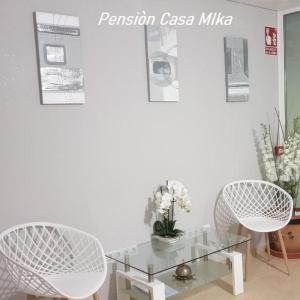 sala de estar con 2 sillas y mesa de cristal en Pensión Casa Mika, en Benicarló
