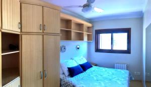 1 dormitorio con cama, armarios y ventana en Apartamento completo no centro de Gramado en Gramado