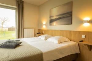 - une chambre avec un grand lit et une fenêtre dans l'établissement HuysHoeve, à Knokke-Heist