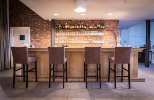 a bar with four chairs and a brick wall at HuysHoeve in Knokke-Heist