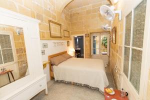 ein Schlafzimmer mit einem Bett in einem Zimmer in der Unterkunft Maria Townhouse Heart of Victoria B&B in Victoria
