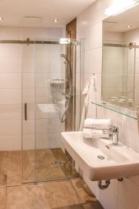 a bathroom with a sink and a glass shower at Weitgasserhof in Schladming