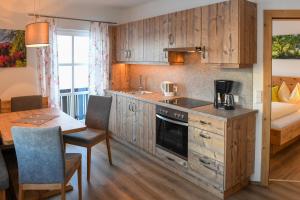 a kitchen with wooden cabinets and a table and a dining room at Weitgasserhof in Schladming
