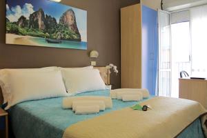 sypialnia z dużym łóżkiem i obrazem na ścianie w obiekcie Hotel Adria Mare w Rimini