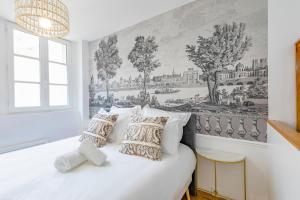 a bedroom with a white bed with pillows at LA SUITE DE L'ORANGERIE in Versailles