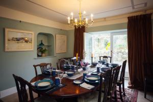 a dining room with a table with chairs and a chandelier at Penrhiw Farm B & B in Goodwick