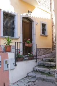 una casa con balcone con piante in vaso di La Casetta Di Otto a Taormina