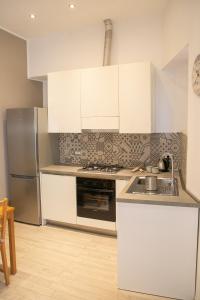 a kitchen with white cabinets and stainless steel appliances at La Casetta Di Otto in Taormina