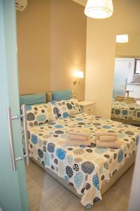 a bedroom with a bed with a comforter on it at La Casetta Di Otto in Taormina