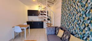 a living room with a couch and a table and a kitchen at Appartement Samuel centre ville Les Herbiers, 10 min du Puy du Fou in Les Herbiers