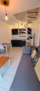 a living room with a couch and a staircase at Appartement Samuel centre ville Les Herbiers, 10 min du Puy du Fou in Les Herbiers +23 photos