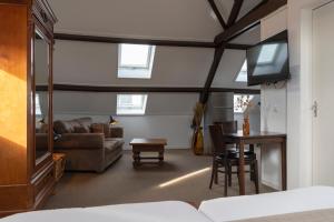 a living room with a couch a table and a tv at 's Lands Welvaren in Aardenburg