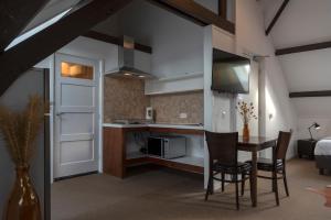 a kitchen and dining room with a table and chairs at 's Lands Welvaren in Aardenburg