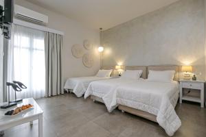 una camera d'albergo con due letti e una finestra di Hotel Grotta a Naxos Chora
