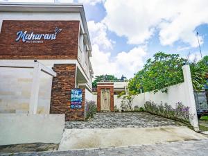 a building with a sign on the side of it at OYO Flagship 90837 Maharani Residence in Seminyak