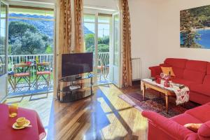ein Wohnzimmer mit einem roten Sofa und einem Flachbildfernseher in der Unterkunft Fernanda Apartment - Levanto in Levanto