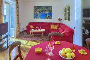 ein Wohnzimmer mit einem roten Sofa und einem Tisch in der Unterkunft Fernanda Apartment - Levanto in Levanto